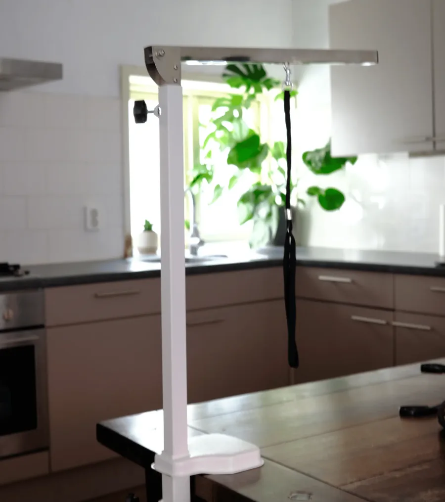 Verstelbare trimbeugel, met een klem tijdelijk aan de rand van een keukentafel bevestigd